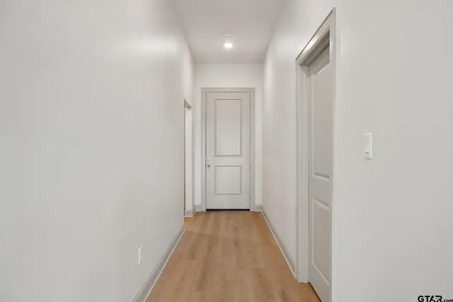 a view of a hallway with wooden floor