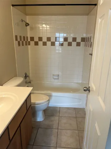 a bathroom with a granite countertop bathtub sink vanity and toilet
