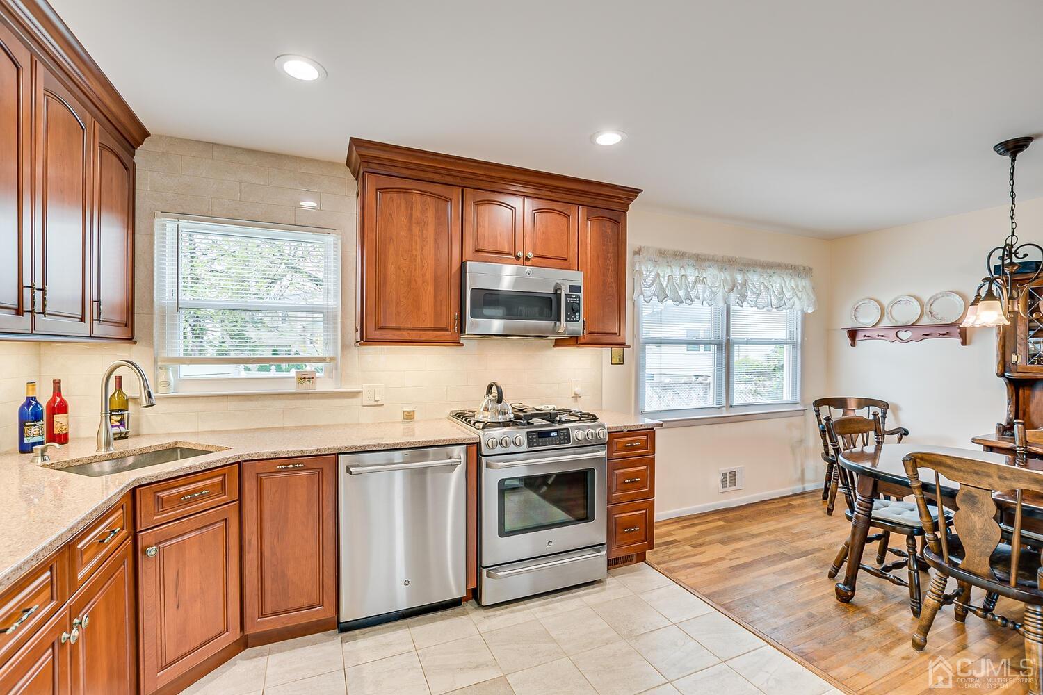 150 Vineyard Road Edison, NJ 08817 - Photo 21 of 33 a kitchen with stainless steel appliances a stove sink microwave and cabinets