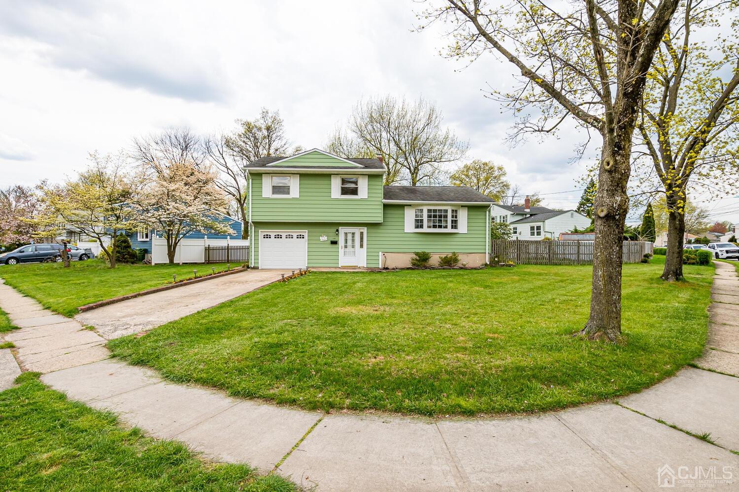150 Vineyard Road Edison, NJ 08817 - Photo 4 of 33 a view of a white house with a big yard and large trees