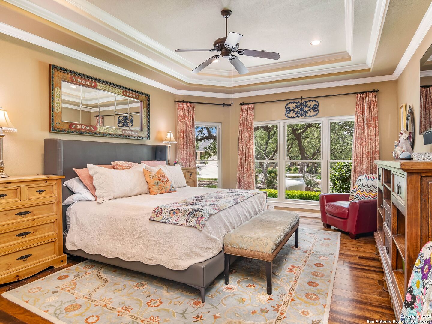 21010 Sky Ridge Avenue San Antonio, TX 78258 - Photo 20 of 70 a bedroom with a large bed and a chandelier