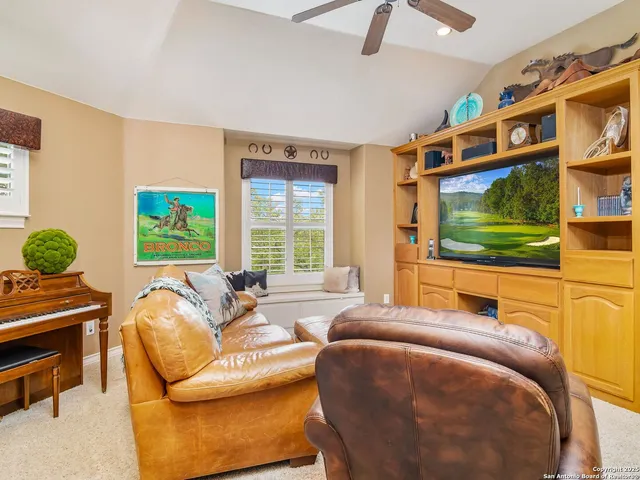 a living room with stainless steel appliances kitchen island granite countertop furniture and a flat screen tv