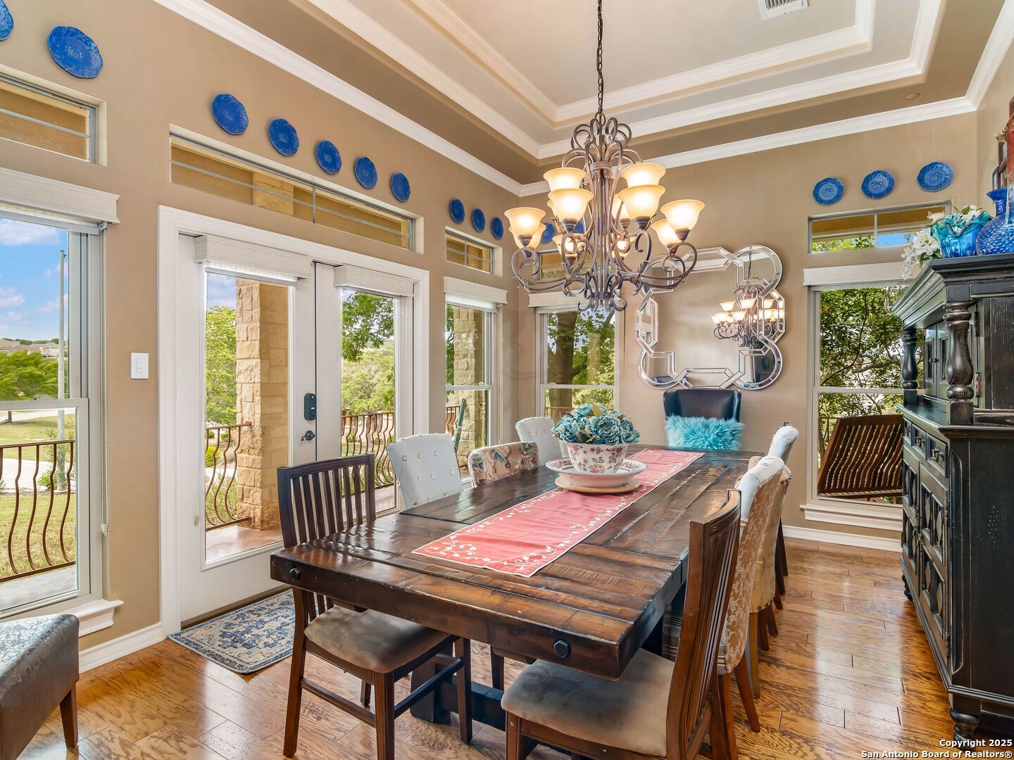 21010 Sky Ridge Avenue San Antonio, TX 78258 - Photo 9 of 70 a view of a dining room with furniture a chandelier and wooden floor