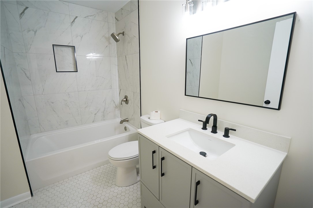 8746 Grubbs-Rex Road Arcanum, OH 45304 - Photo 10 of 38 This modern bathroom features a sleek vanity and a tiled shower, offering clean lines and contemporary style.