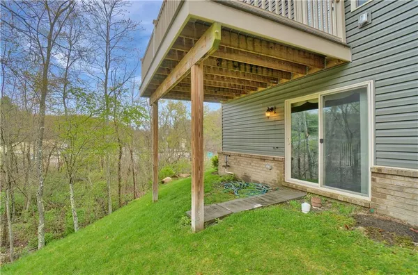 a view of a small house with a small yard and wooden fence