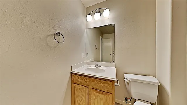 a bathroom with a sink a toilet and a mirror