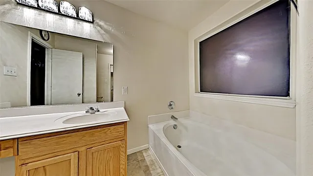 a bathroom with a bathtub sink and mirror