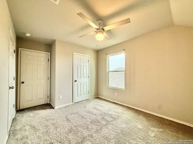 an empty room with a ceiling fan and a window