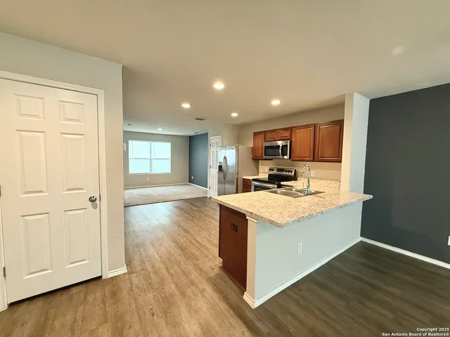 a kitchen with stainless steel appliances granite countertop a stove and a refrigerator