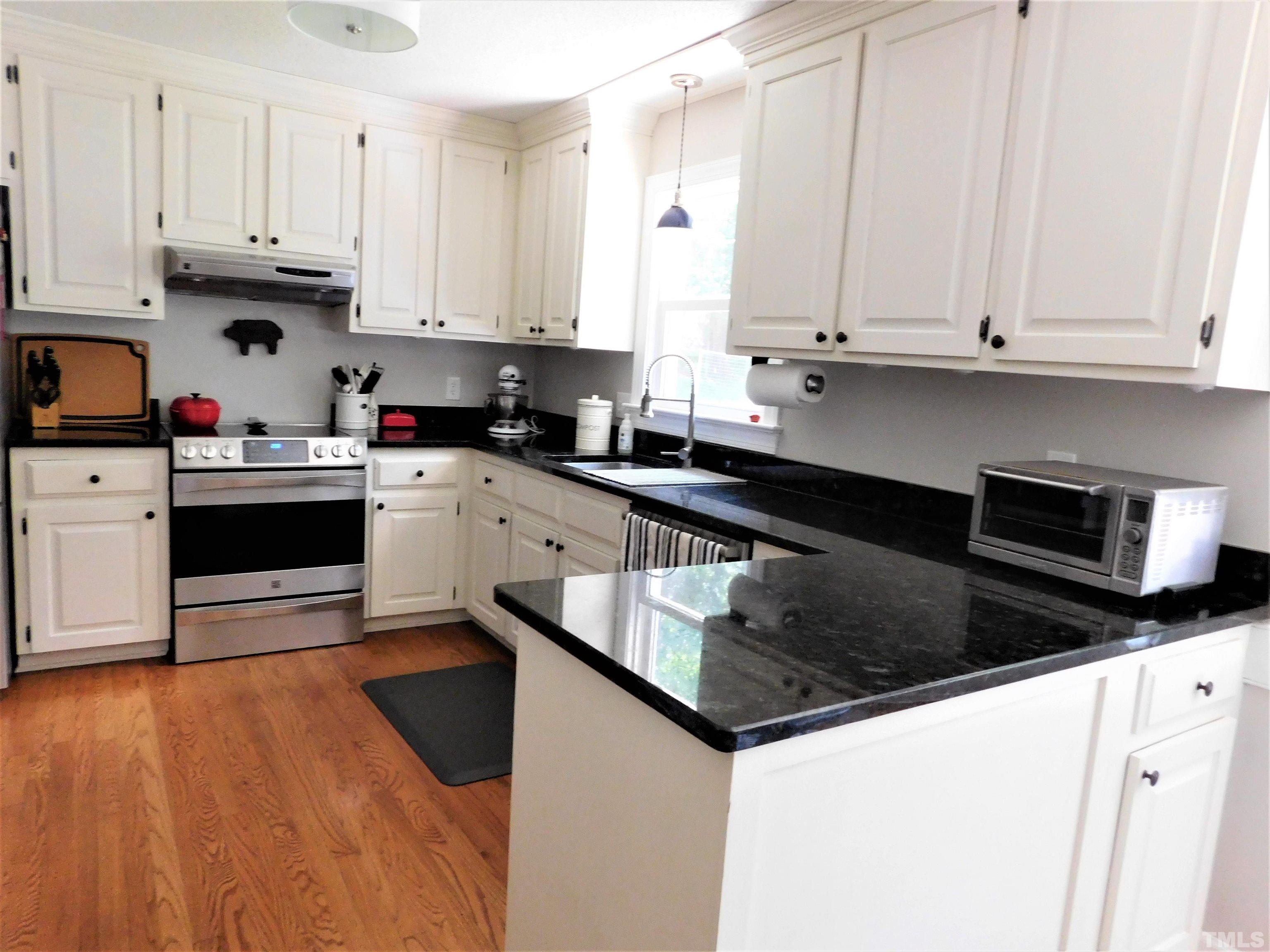 11417 Pacesferry Drive Raleigh, NC 27614 - Photo 14 of 39 a kitchen with stainless steel appliances granite countertop a stove a sink and white cabinets