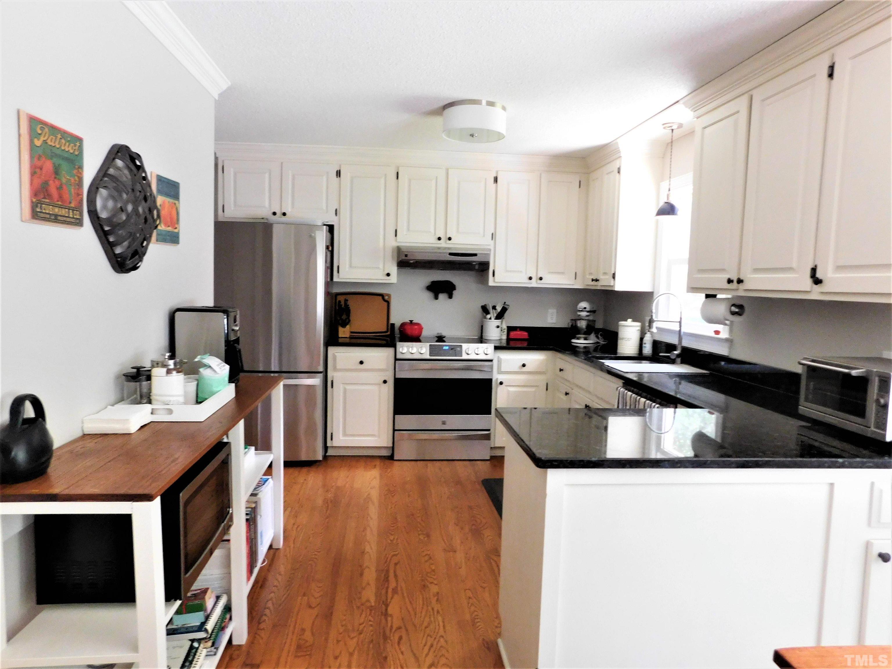 11417 Pacesferry Drive Raleigh, NC 27614 - Photo 15 of 39 a kitchen with stainless steel appliances granite countertop a stove a refrigerator a sink a stove and white cabinets with wooden floor