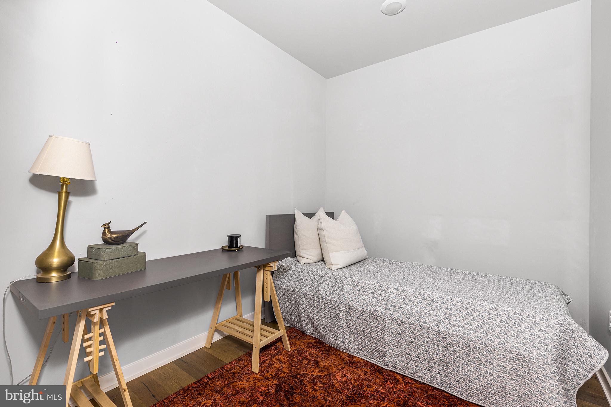 5542-44 Ridge Avenue, Unit 314 Philadelphia, PA 19128 - Photo 11 of 19 a bedroom with a bed and a lamp