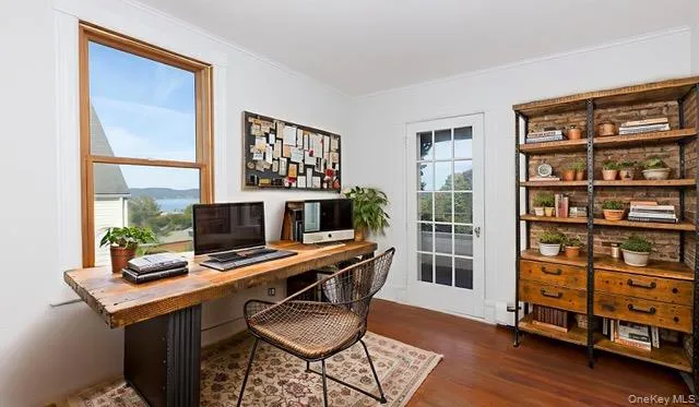 a view of a workspace with furniture and a window