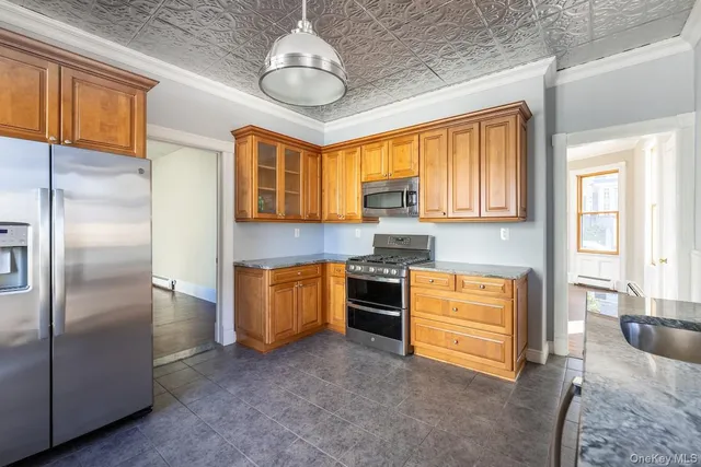 a kitchen with stainless steel appliances granite countertop a refrigerator a stove and a sink with cabinets