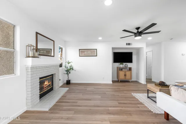 a living room with furniture a fireplace and a flat screen tv
