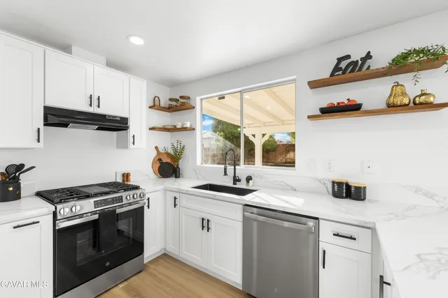 a kitchen with cabinets stainless steel appliances and wooden floor