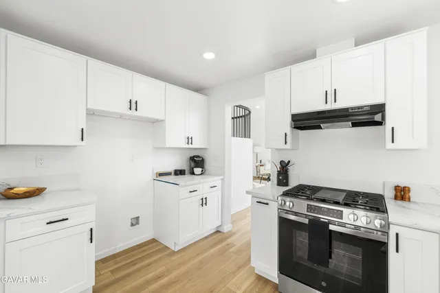 a very nice looking room with a large window wooden floor and chandelier