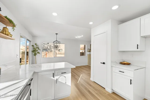 a bathroom with a sink a mirror and a potted plant