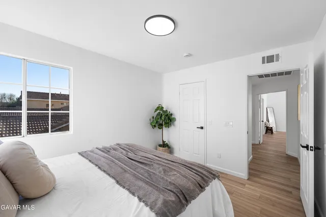 a bedroom with a bed and painting on the wall