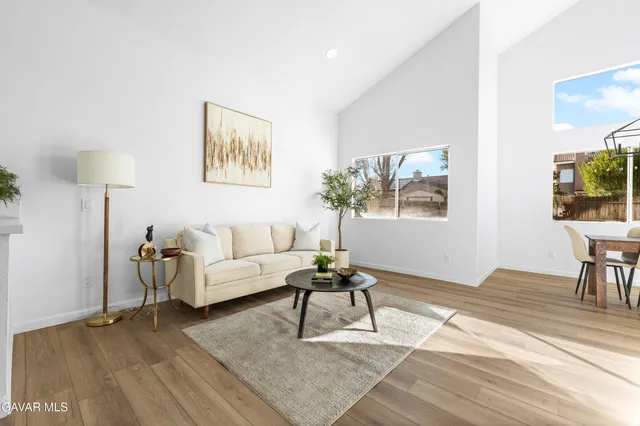 a living room with furniture a desk and chair with wooden floor