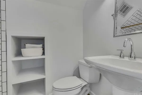a bathroom with a toilet a sink and mirror