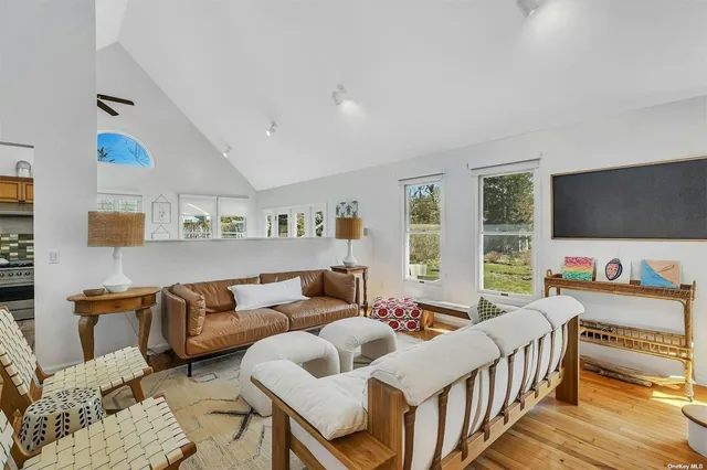 a kitchen with stainless steel appliances granite countertop a stove top oven a sink dishwasher a dining table and chairs with wooden floor