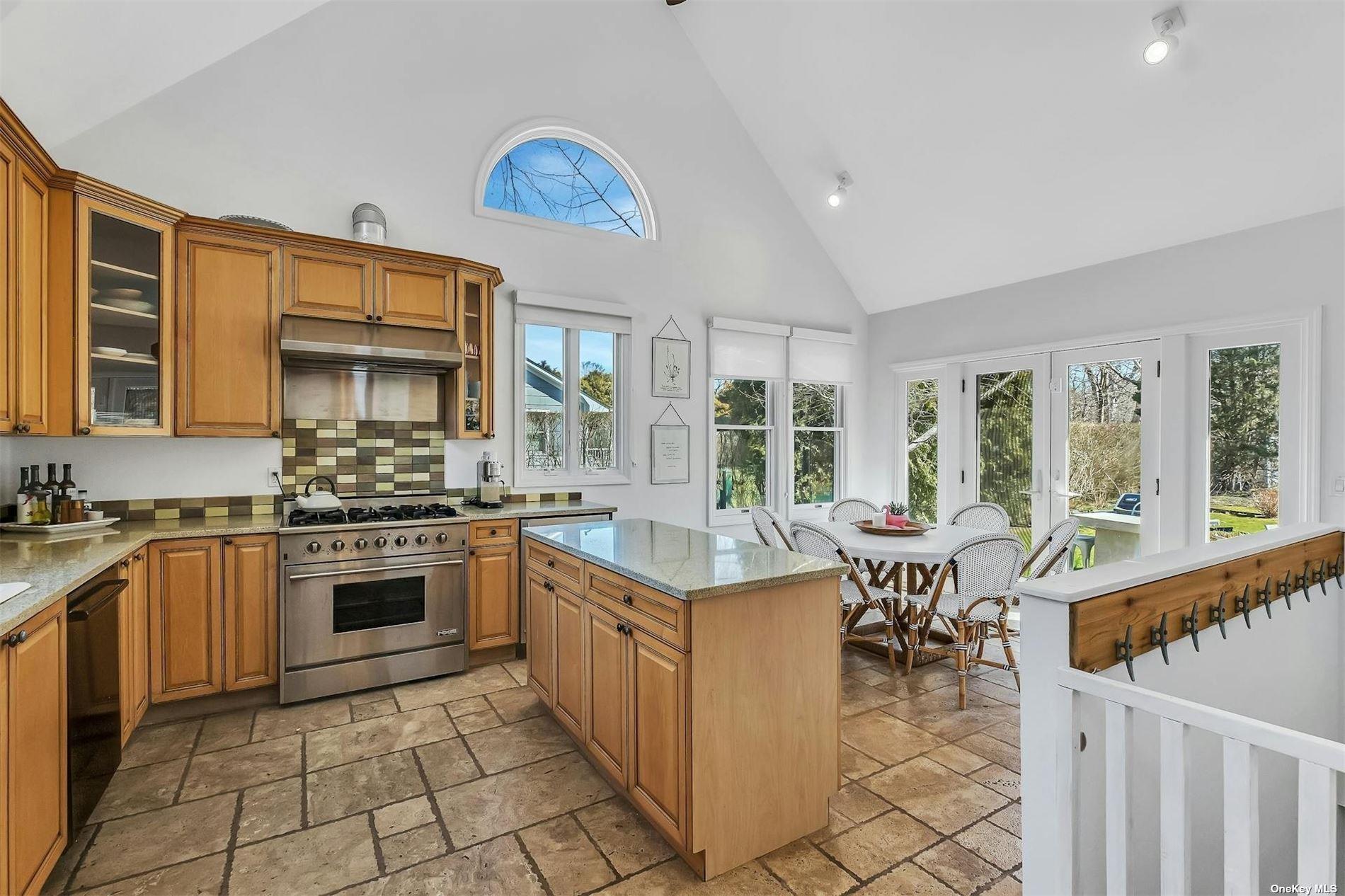 6 Nidzyn Avenue Remsenburg, NY 11960 - Photo 9 of 31 a kitchen with stainless steel appliances granite countertop a stove top oven a sink dishwasher a dining table and chairs with wooden floor