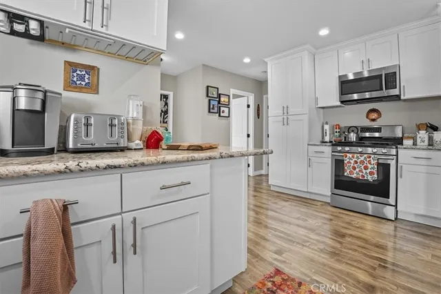 a kitchen with stainless steel appliances granite countertop a stove a sink and a microwave