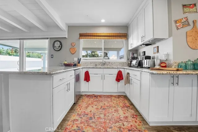 a kitchen with kitchen island wooden cabinets a stove a sink and a window