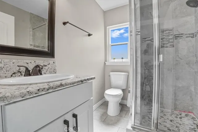 a bathroom with a granite countertop sink a toilet and a mirror