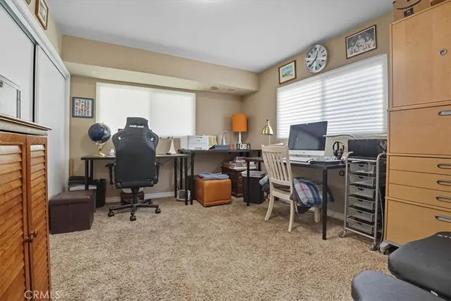 a view of a workspace with furniture and a window