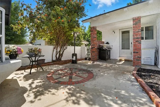 a view of a backyard with table and chairs a fire pit and two large trees