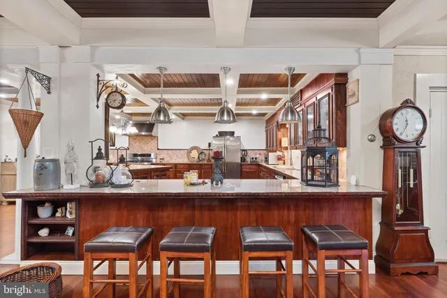 a kitchen with stainless steel appliances a table and chairs in it