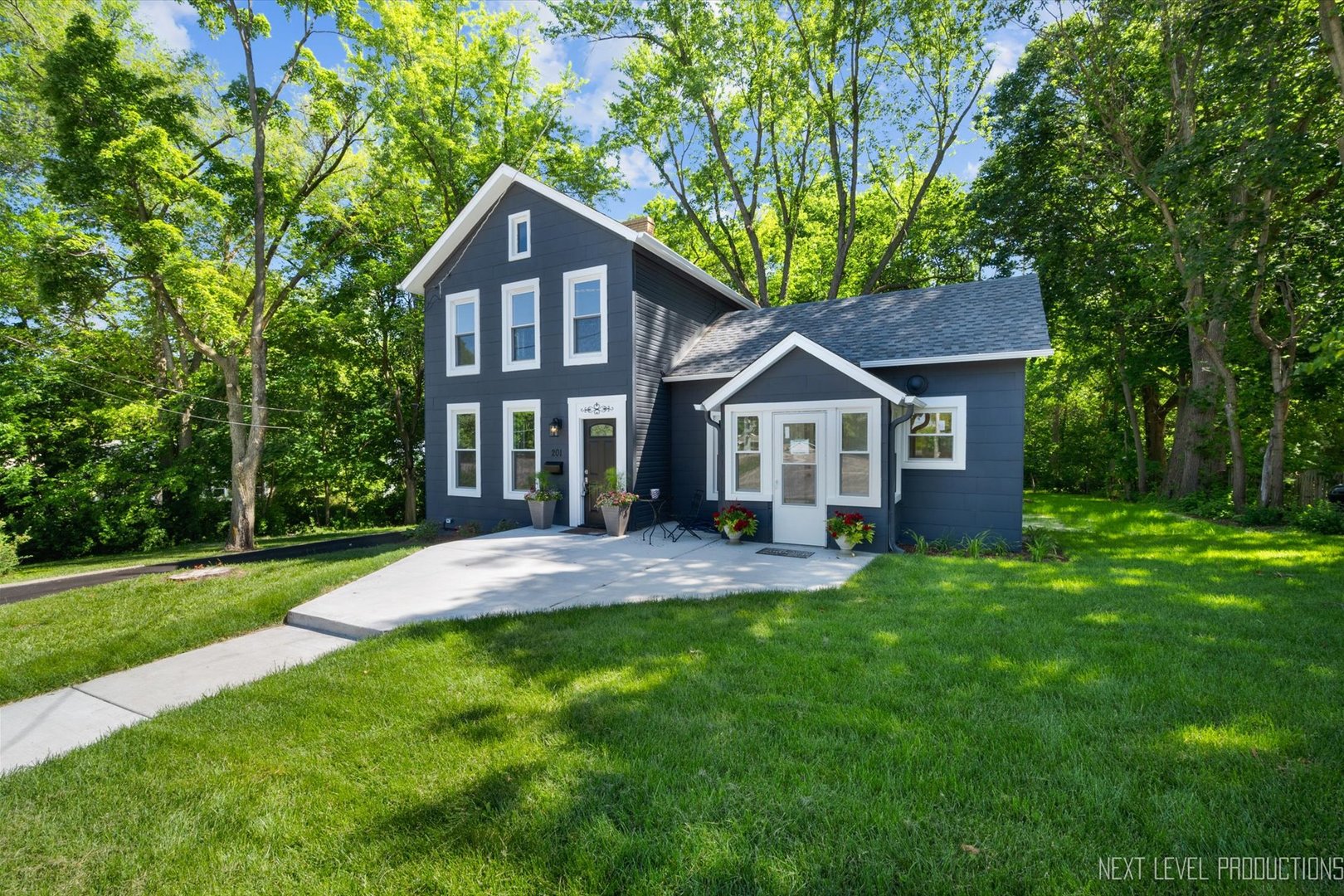 a front view of a house with a yard and green space