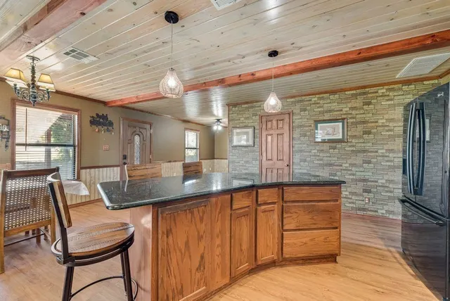 a dining hall with stainless steel appliances granite countertop a sink and cabinets