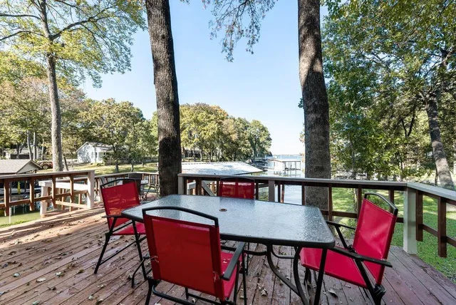 a balcony with wooden floor table and chairs