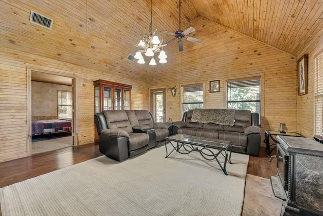 a living room with furniture a chandelier and a flat screen tv