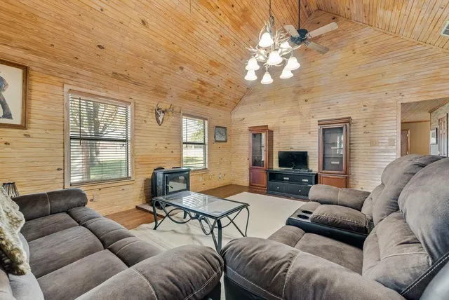 a living room with furniture a large window and a chandelier