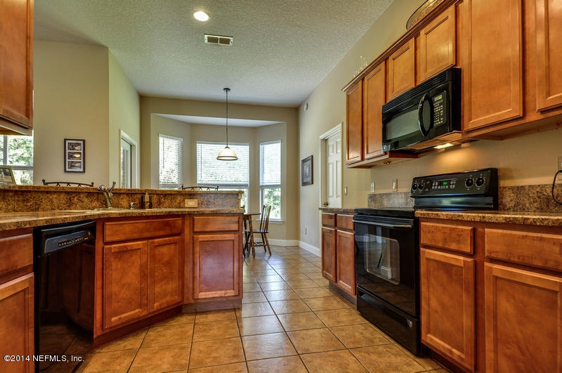 55108 Bear Run Road Callahan, FL 32011 - Photo 12 of 33 a kitchen with stainless steel appliances granite countertop a stove a sink and a microwave