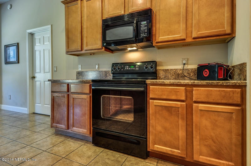 55108 Bear Run Road Callahan, FL 32011 - Photo 14 of 33 a kitchen with stainless steel appliances granite countertop a stove microwave and cabinets