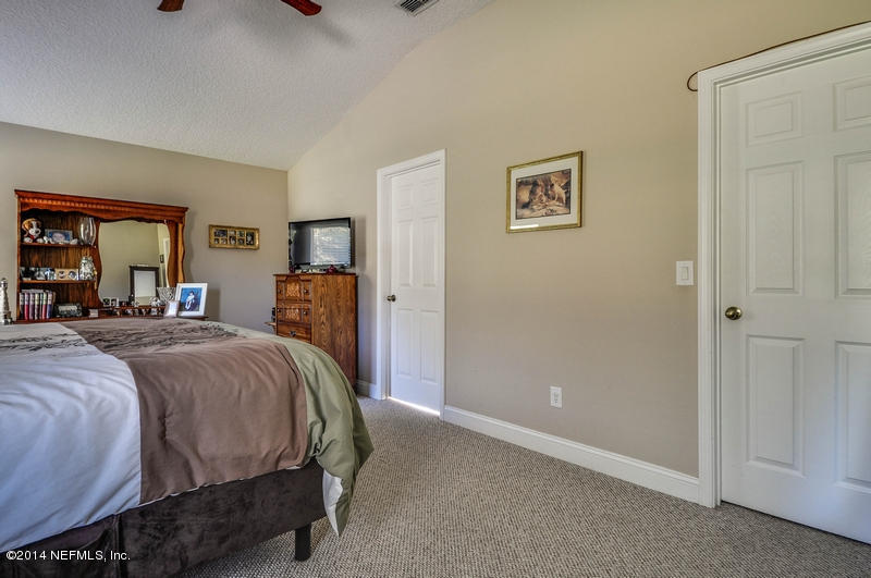 55108 Bear Run Road Callahan, FL 32011 - Photo 16 of 33 a bedroom with a bed and a large mirror