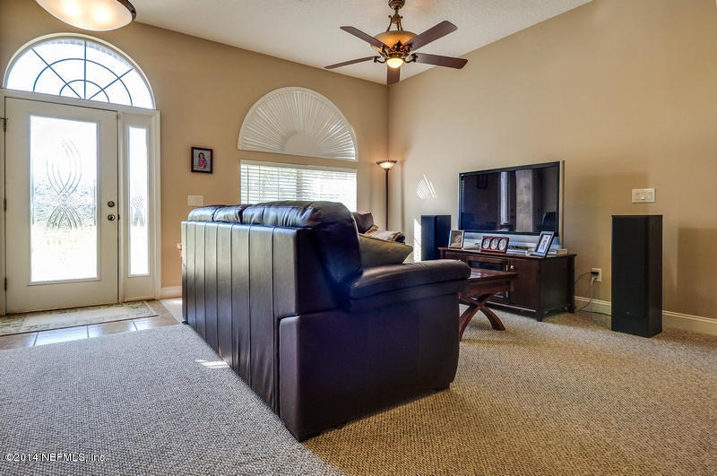 55108 Bear Run Road Callahan, FL 32011 - Photo 4 of 33 a living room with furniture a fireplace and a flat screen tv