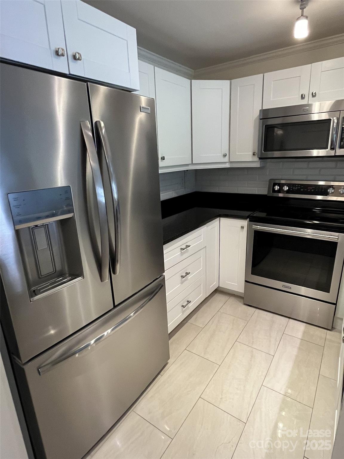 1323 Queens Road, Unit 312 Charlotte, NC 28207 - Photo 13 of 32 a kitchen with stainless steel appliances a refrigerator sink and microwave