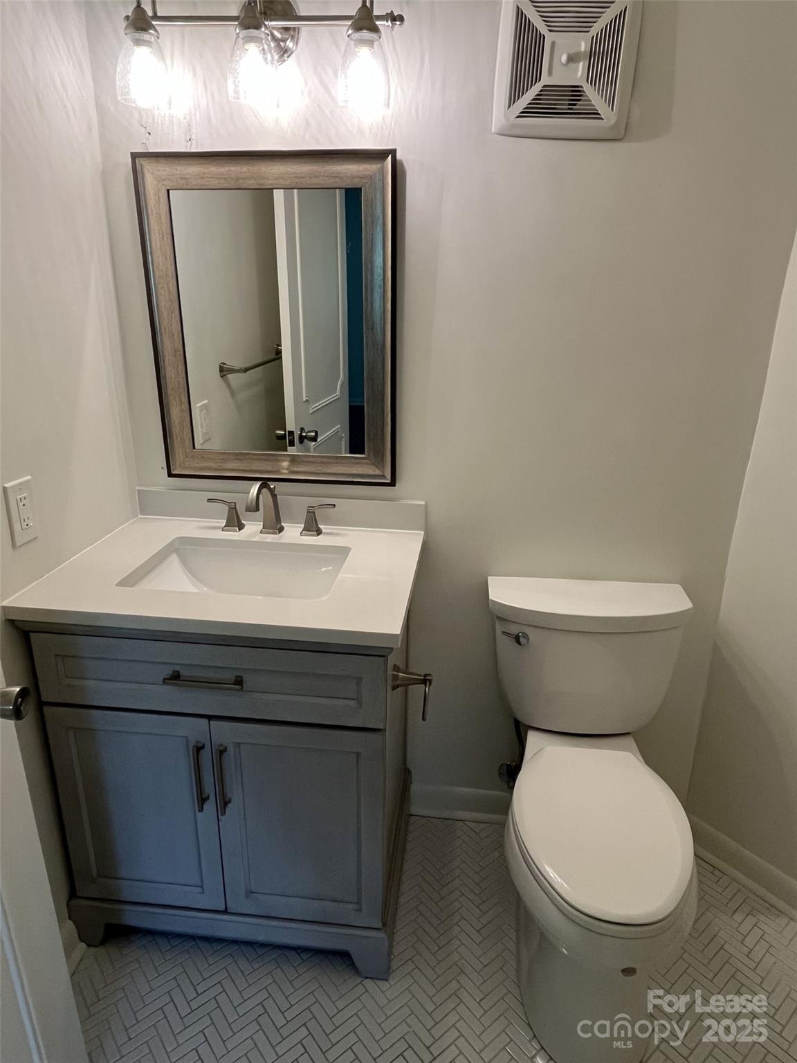 1323 Queens Road, Unit 312 Charlotte, NC 28207 - Photo 16 of 32 a bathroom with a toilet sink and mirror