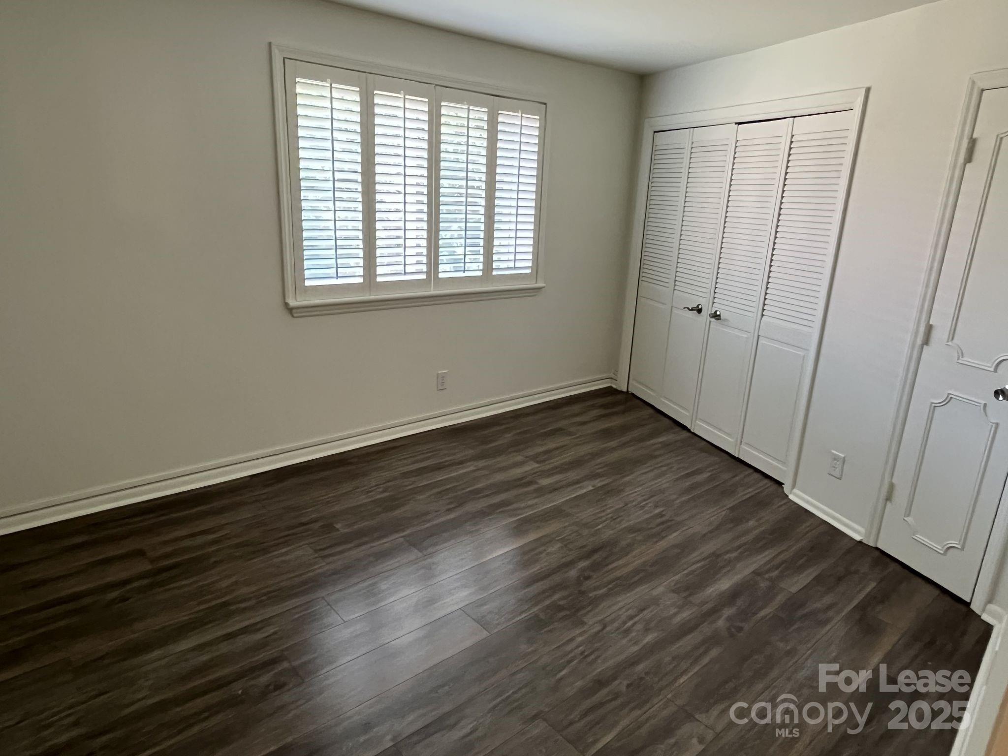 1323 Queens Road, Unit 312 Charlotte, NC 28207 - Photo 18 of 32 an empty room with wooden floor and windows