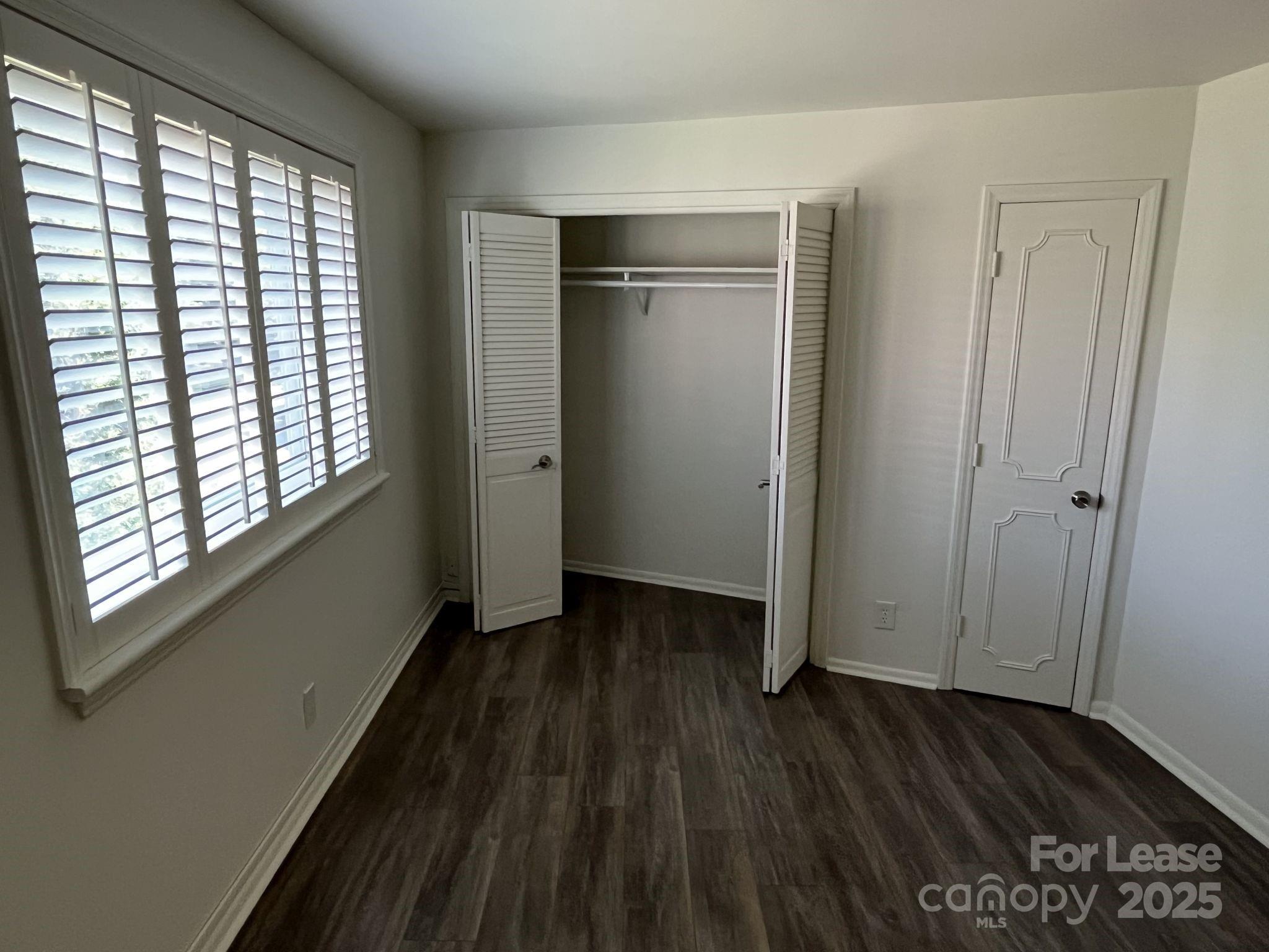 1323 Queens Road, Unit 312 Charlotte, NC 28207 - Photo 19 of 32 an empty room with wooden floor and windows