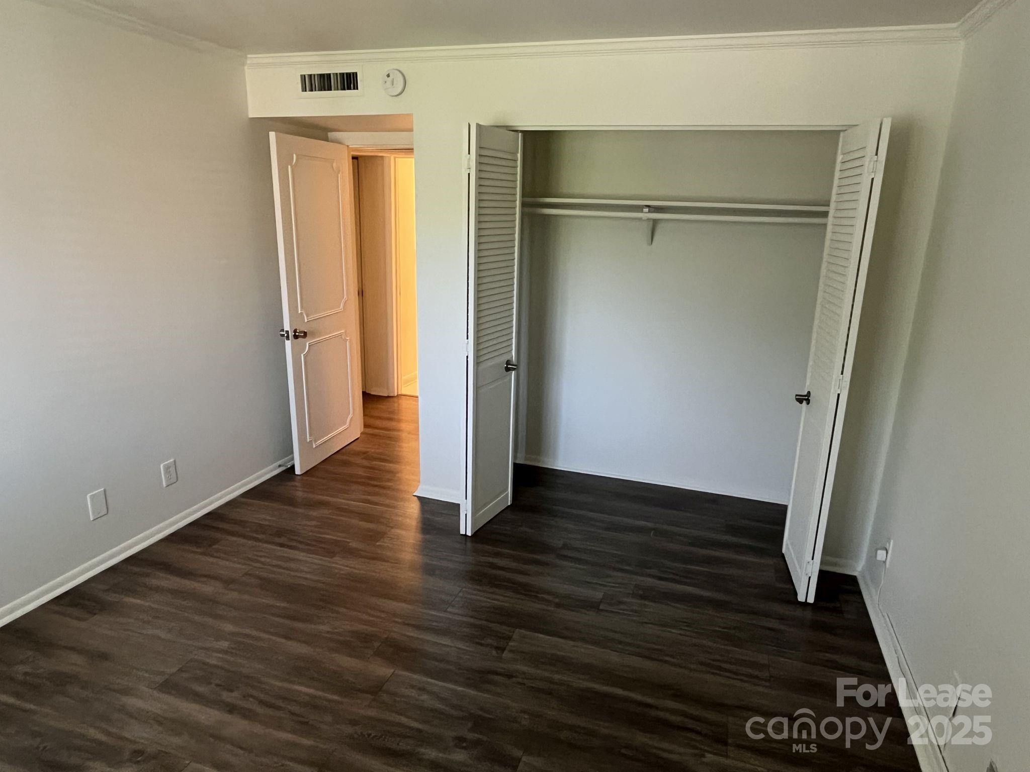 1323 Queens Road, Unit 312 Charlotte, NC 28207 - Photo 21 of 32 a view of an empty room with wooden floor and a window