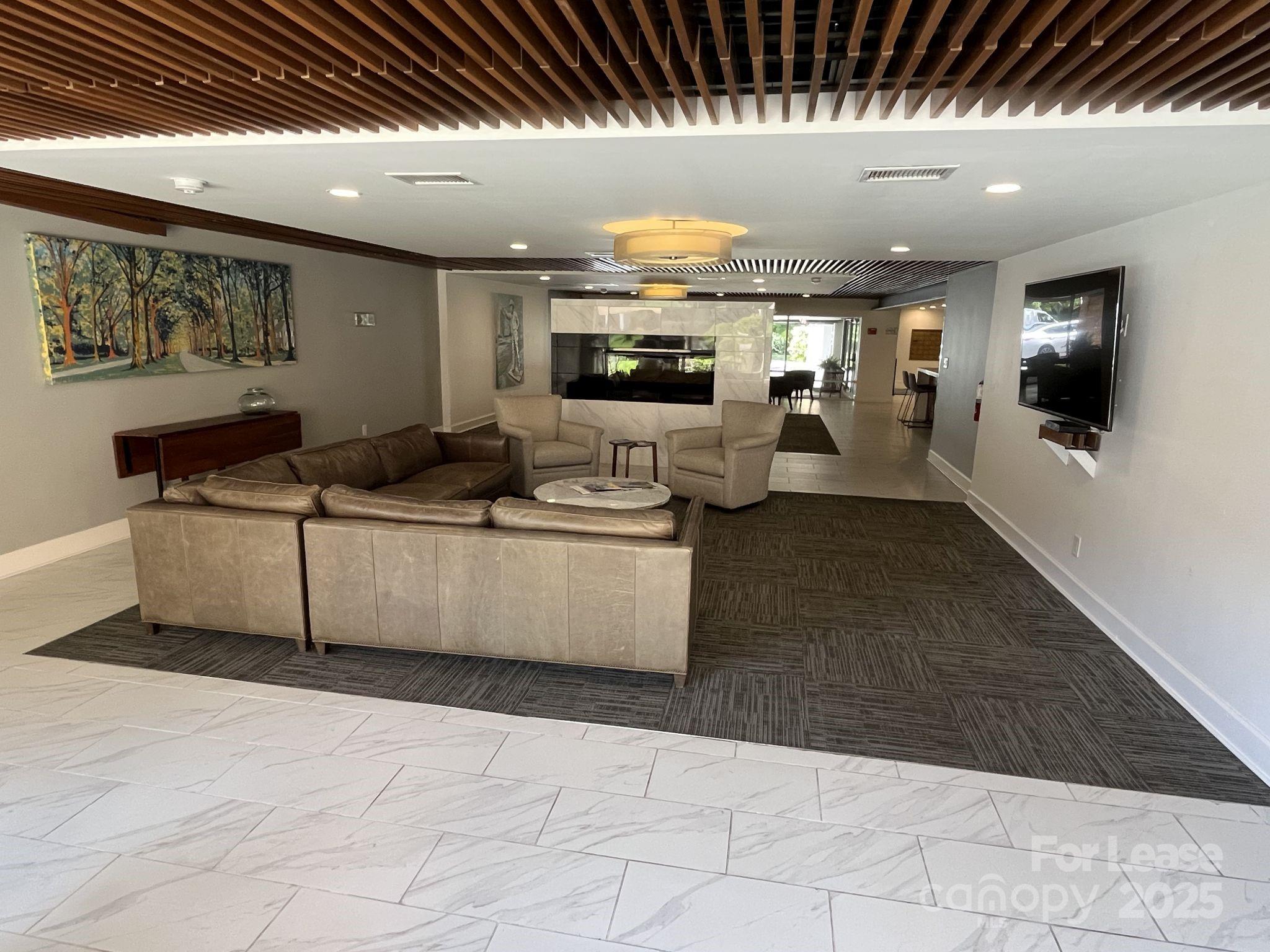 1323 Queens Road, Unit 312 Charlotte, NC 28207 - Photo 29 of 32 a living room with furniture and a flat screen tv