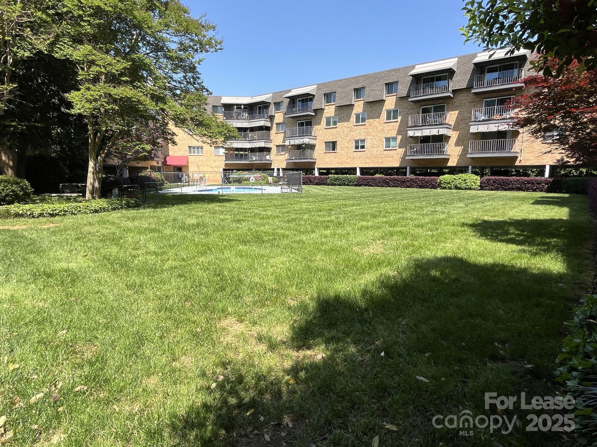 1323 Queens Road, Unit 312 Charlotte, NC 28207 - Photo 31 of 32 a tall white building with a yard