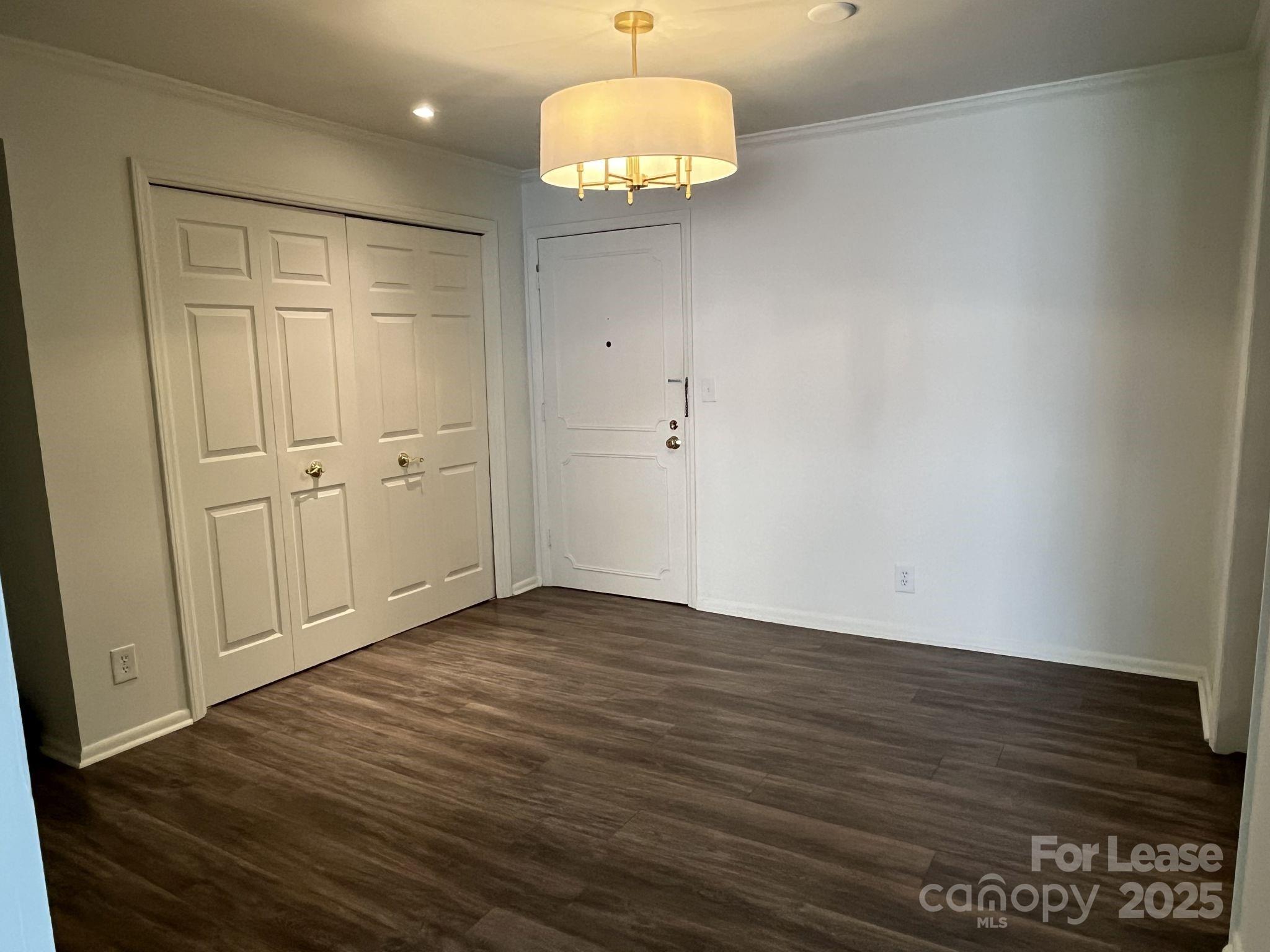 1323 Queens Road, Unit 312 Charlotte, NC 28207 - Photo 4 of 32 a view of an empty room with wooden floor and a window